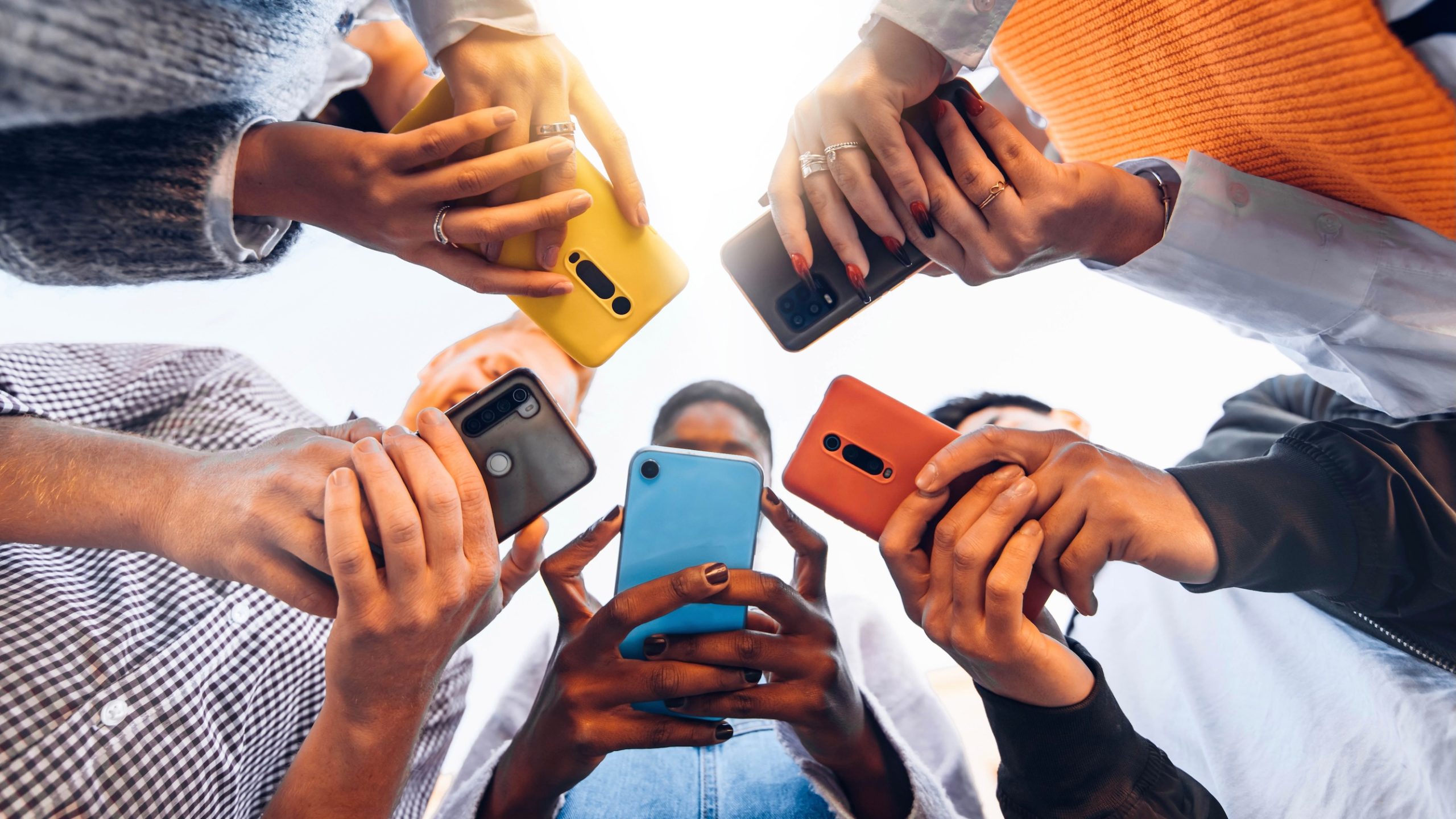 Connect header image - Teens/young adults holding colourful cellphones